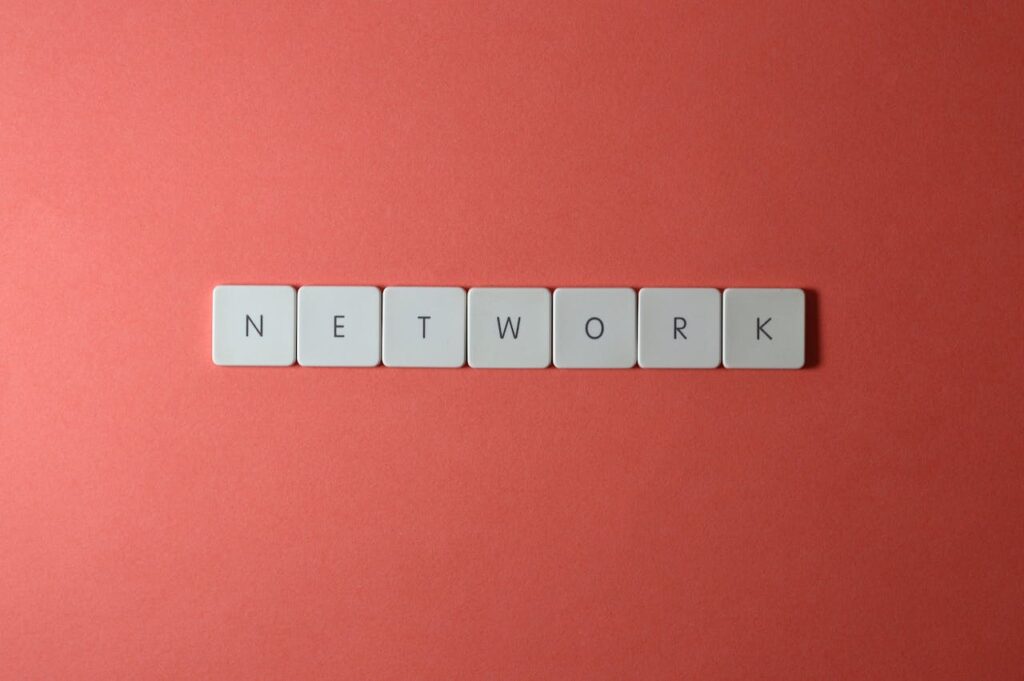 White keyboard tiles spelling 'NETWORK' on a vibrant red surface, minimalist design.